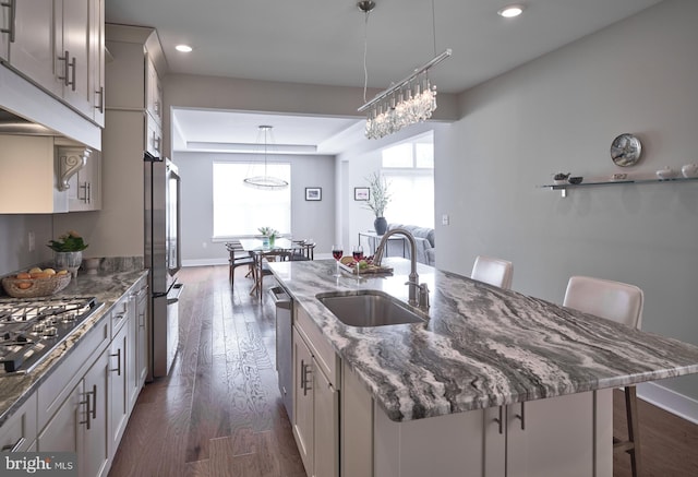 kitchen with a center island with sink, plenty of natural light, appliances with stainless steel finishes, and a sink
