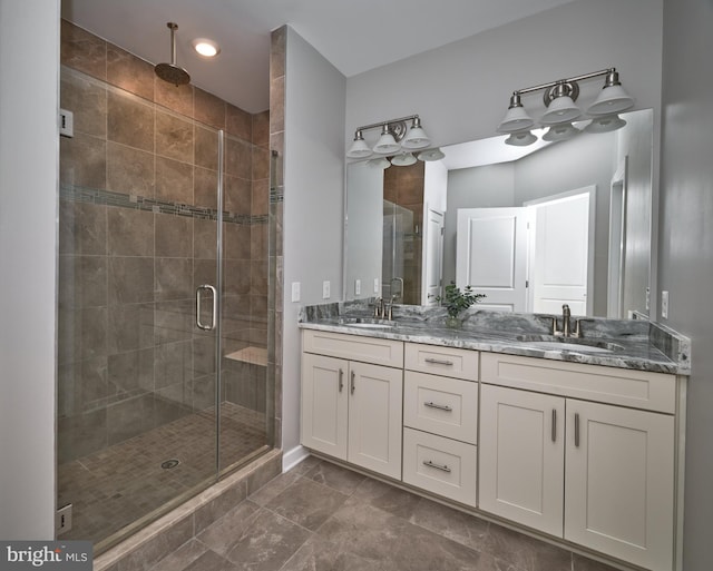 bathroom featuring double vanity, baseboards, a shower stall, and a sink