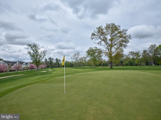 view of home's community featuring golf course view and a lawn