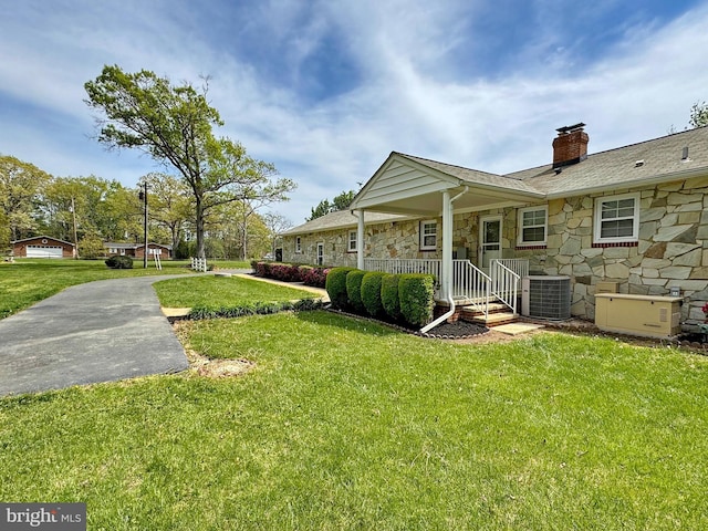 view of yard featuring cooling unit and covered porch