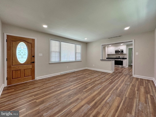 foyer entrance featuring recessed lighting, visible vents, dark wood-style flooring, and baseboards