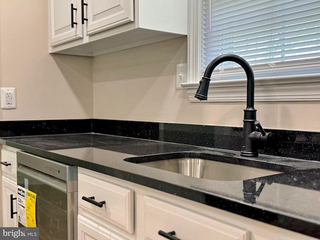 kitchen featuring white cabinetry, stainless steel dishwasher, and a sink