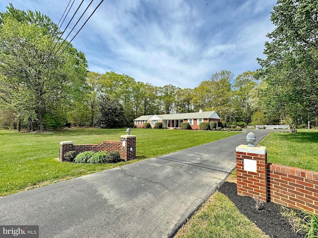 view of front of house with aphalt driveway and a front yard