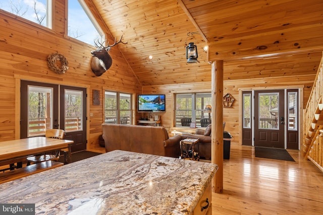 dining area with french doors, wooden walls, healthy amount of natural light, light wood finished floors, and wooden ceiling