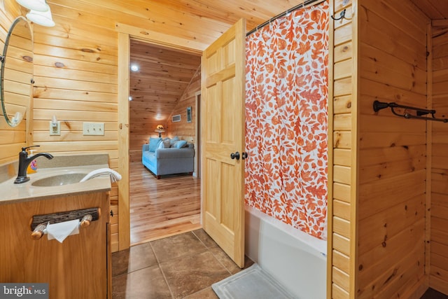 full bath with wood ceiling, vaulted ceiling, tile patterned floors, vanity, and wood walls