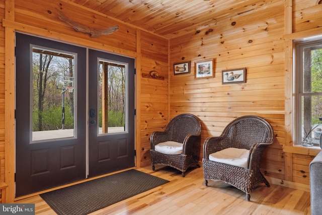 living area with light wood finished floors and wooden walls