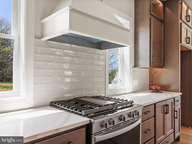 149 Matthew Dr, Chambersburg, PA 17201 - kitchen with premium range hood, stainless steel gas range oven, light stone countertops, and backsplash