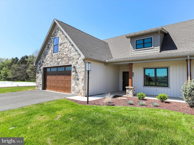 149 Matthew Dr, Chambersburg, PA 17201 - view of front of house featuring a shingled roof, stone siding, a front lawn, and aphalt driveway