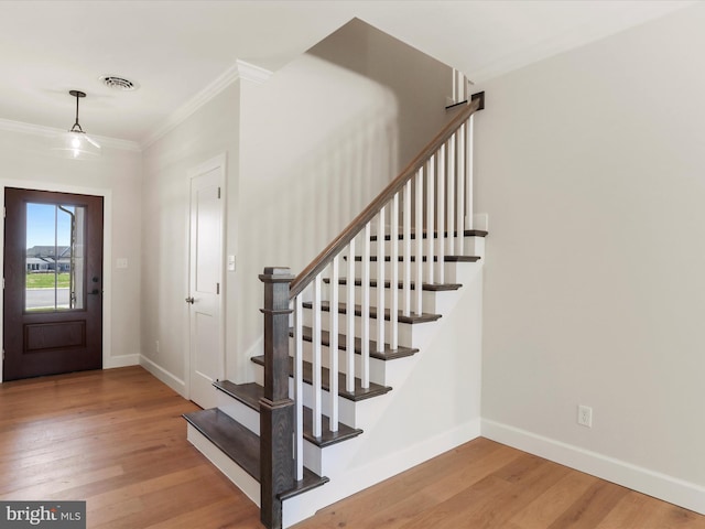 149 Matthew Dr, Chambersburg, PA 17201 - foyer featuring crown molding, visible vents, wood finished floors, baseboards, and stairway