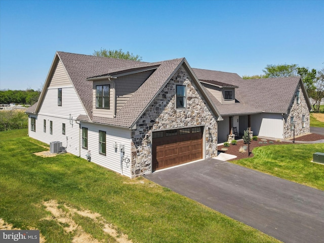 149 Matthew Dr, Chambersburg, PA 17201 - view of front of house featuring a front yard, central AC unit, stone siding, and aphalt driveway