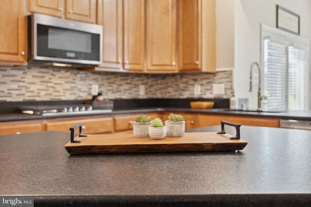 16 Zachary Ct, Boonsboro, MD 21713 - kitchen featuring stainless steel microwave, dark countertops, a sink, stovetop, and decorative backsplash