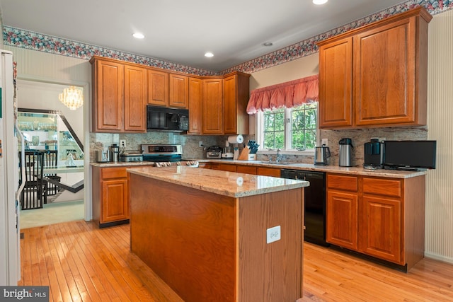 25 Stallion Cir, Upper Holland, PA 19053 - kitchen with decorative backsplash, light stone counters, a kitchen island, black appliances, and light wood-type flooring
