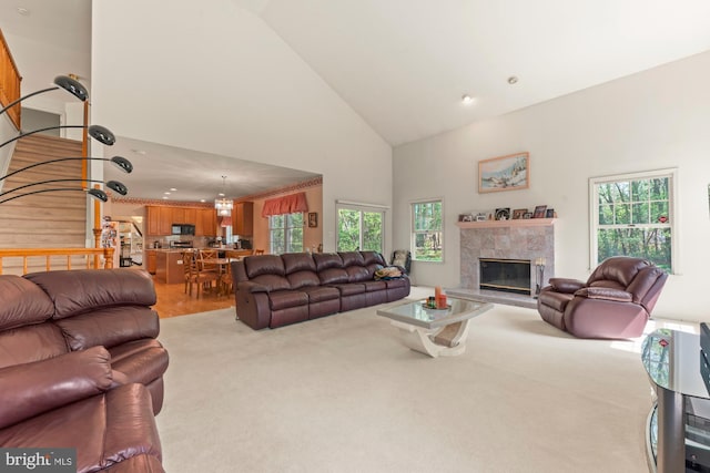 25 Stallion Cir, Upper Holland, PA 19053 - living room featuring a high end fireplace, high vaulted ceiling, carpet flooring, and a healthy amount of sunlight