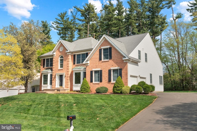 25 Stallion Cir, Upper Holland, PA 19053 - view of front of home featuring aphalt driveway, a front lawn, an attached garage, and brick siding