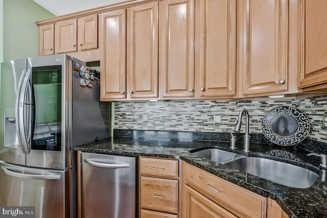 kitchen featuring stainless steel refrigerator with ice dispenser, a sink, decorative backsplash, and dark stone counters