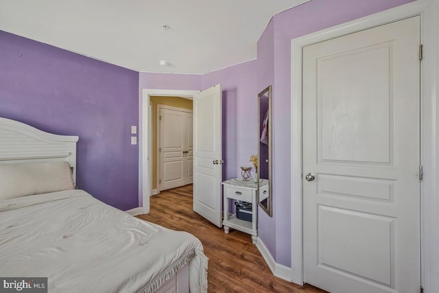 bedroom with baseboards and dark wood finished floors