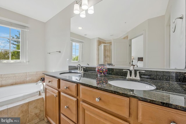 full bathroom featuring a garden tub, a sink, a stall shower, and double vanity