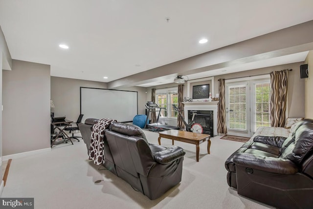 carpeted living room featuring a premium fireplace, baseboards, recessed lighting, and a healthy amount of sunlight