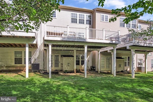 back of property with central AC unit, a yard, and a deck