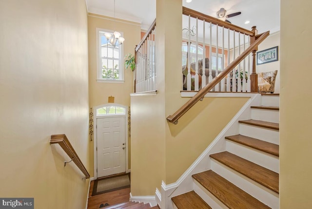 stairs featuring an inviting chandelier, baseboards, and wood finished floors
