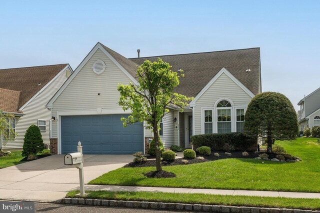 view of front facade with a garage, a front lawn, a shingled roof, and concrete driveway