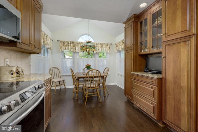 dining room with baseboards, an inviting chandelier, lofted ceiling, and dark wood-type flooring