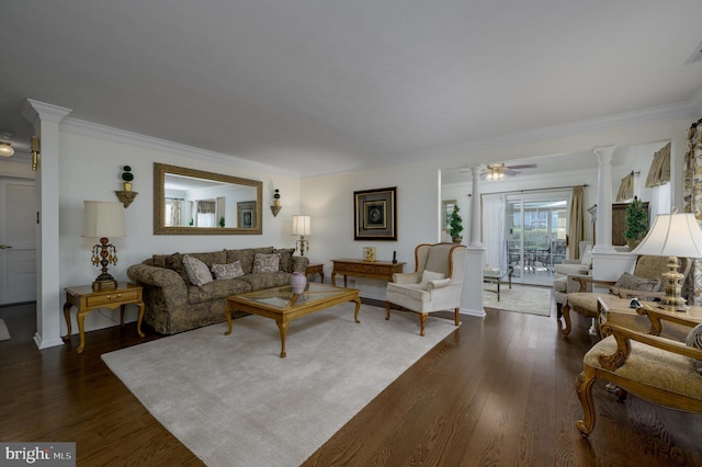 living area featuring ornate columns, ornamental molding, dark wood-style flooring, and a ceiling fan