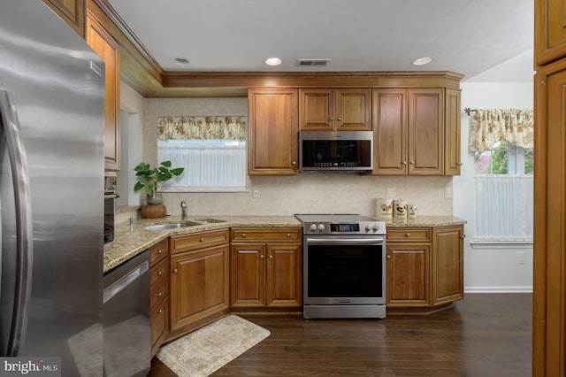 kitchen with brown cabinets, a healthy amount of sunlight, and stainless steel appliances