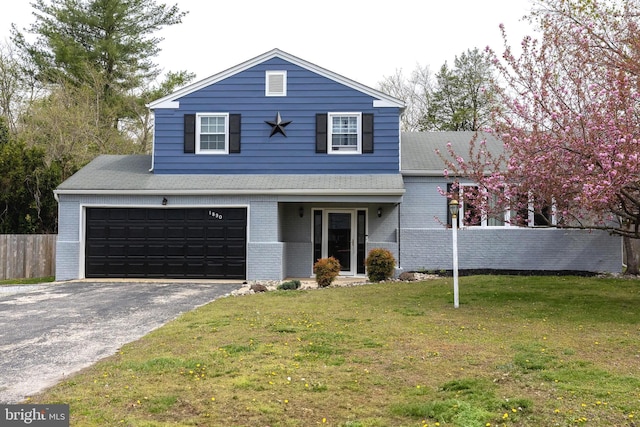 split level home featuring aphalt driveway, roof with shingles, fence, brick siding, and a front lawn