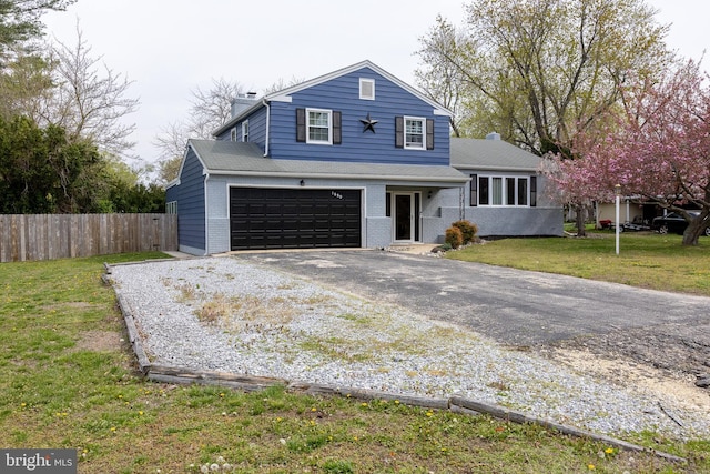 view of front of home featuring a chimney, brick siding, fence, driveway, and a front lawn