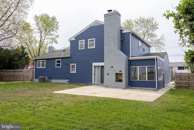 rear view of property with a chimney, fence, a lawn, and a patio area