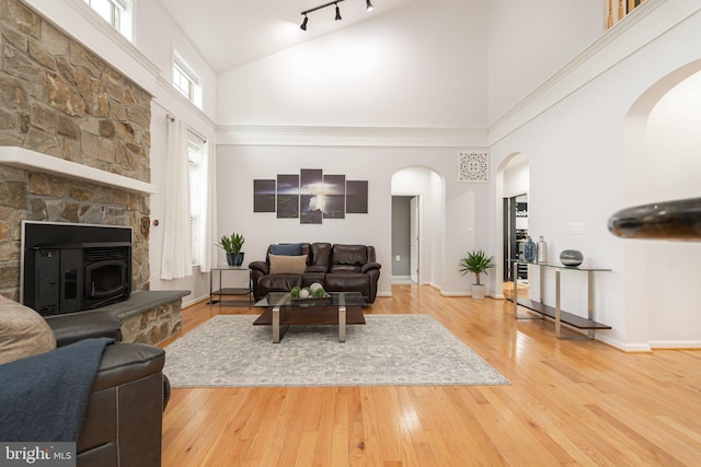 189 Potomac Crossing St, Charles Town, WV 25414 - living room with high vaulted ceiling, arched walkways, wood-type flooring, baseboards, and a fireplace