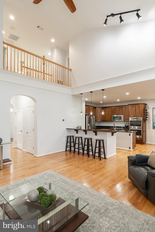 189 Potomac Crossing St, Charles Town, WV 25414 - living room with a high ceiling, arched walkways, ceiling fan, light wood-type flooring, and recessed lighting