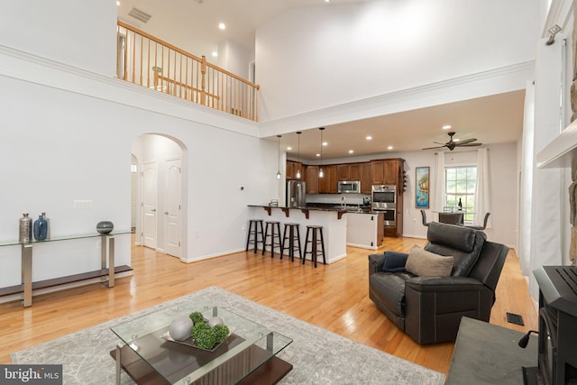 189 Potomac Crossing St, Charles Town, WV 25414 - living room featuring arched walkways, a ceiling fan, light wood-style floors, recessed lighting, and a towering ceiling