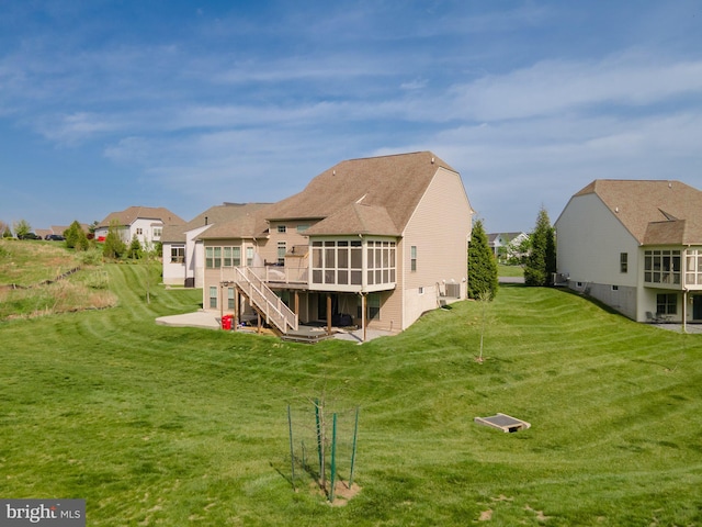 189 Potomac Crossing St, Charles Town, WV 25414 - rear view of house featuring a sunroom, a wooden deck, a lawn, a shingled roof, and a residential view