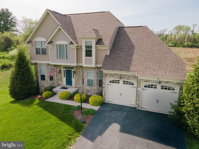 189 Potomac Crossing St, Charles Town, WV 25414 - view of front of house featuring stone siding, an attached garage, asphalt driveway, and a front yard