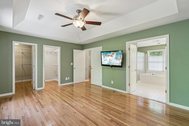 24 Monument Dr, Stafford, VA 22554 - unfurnished bedroom with ensuite bath, light wood-style floors, baseboards, a tray ceiling, and visible vents