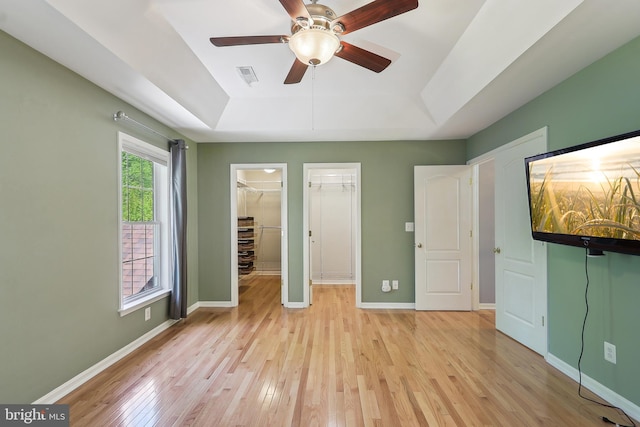 24 Monument Dr, Stafford, VA 22554 - unfurnished bedroom with visible vents, baseboards, a raised ceiling, a spacious closet, and light wood-style flooring