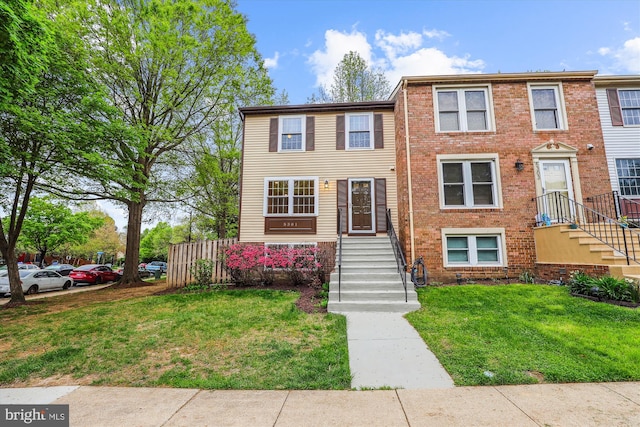 view of property featuring a front yard and brick siding