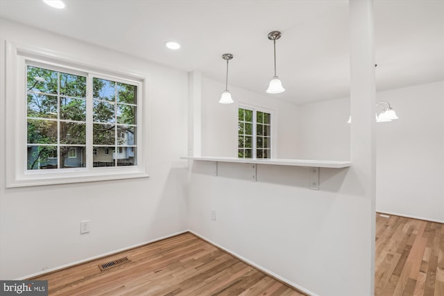 interior space featuring visible vents, wood finished floors, hanging light fixtures, and recessed lighting