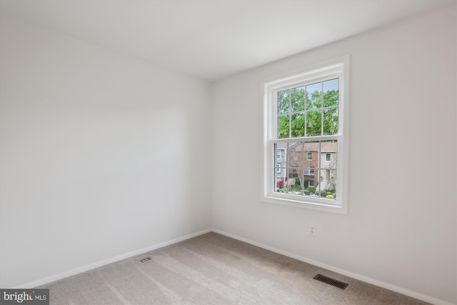 unfurnished room with baseboards, visible vents, and carpet flooring