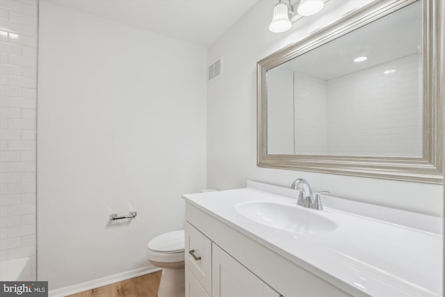 full bathroom with visible vents, baseboards, toilet, wood finished floors, and vanity