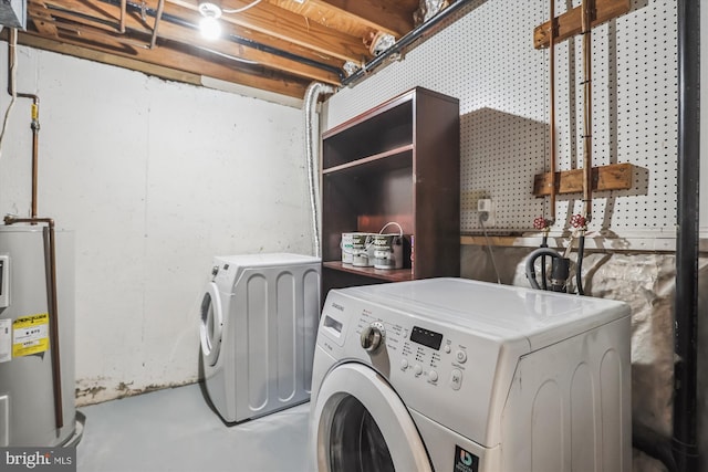 washroom with electric water heater, separate washer and dryer, and laundry area