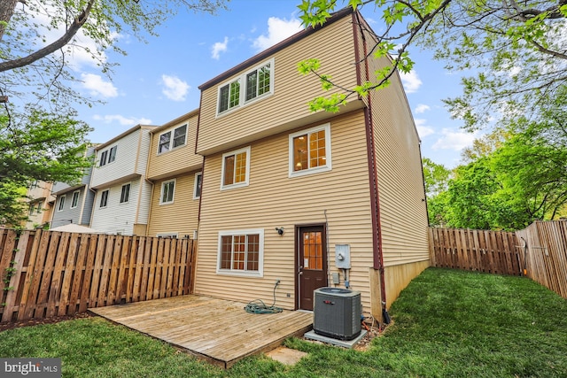 rear view of house featuring a wooden deck, a fenced backyard, central AC unit, and a yard