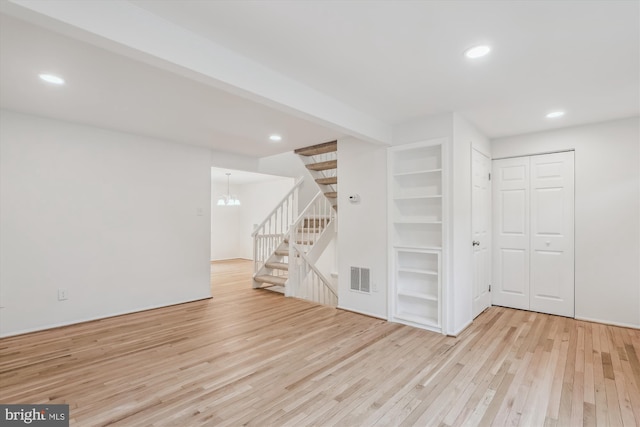 interior space with hardwood / wood-style flooring, visible vents, an inviting chandelier, recessed lighting, and stairs