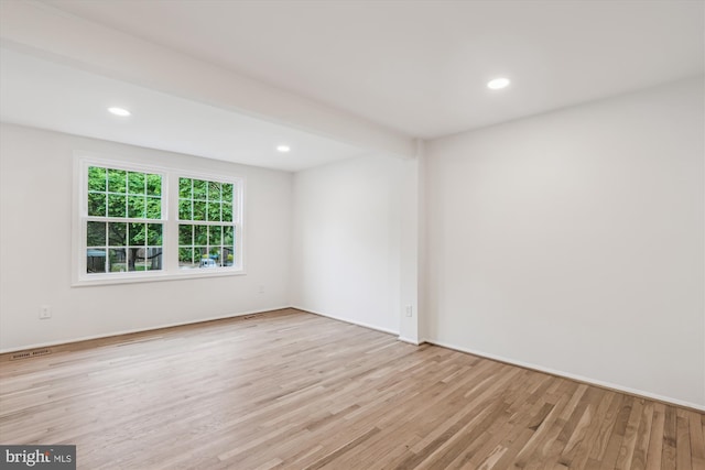 spare room featuring baseboards, visible vents, wood finished floors, and recessed lighting