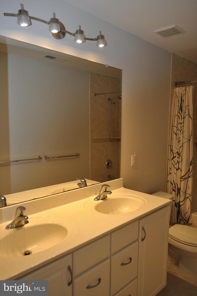 bathroom with a shower with curtain, a sink, and visible vents
