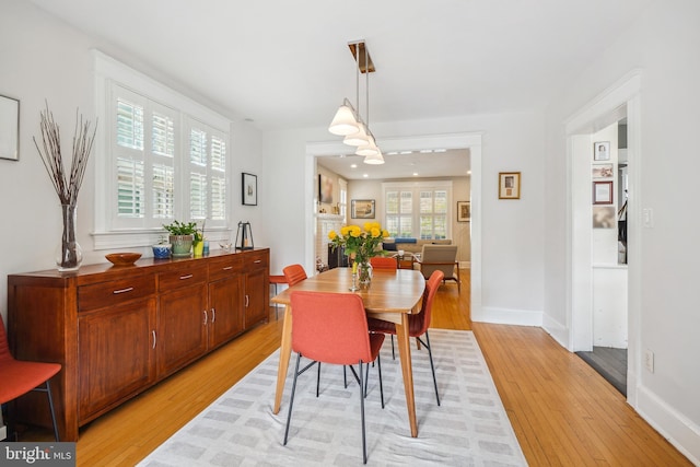dining space featuring light wood-style floors, baseboards, and recessed lighting