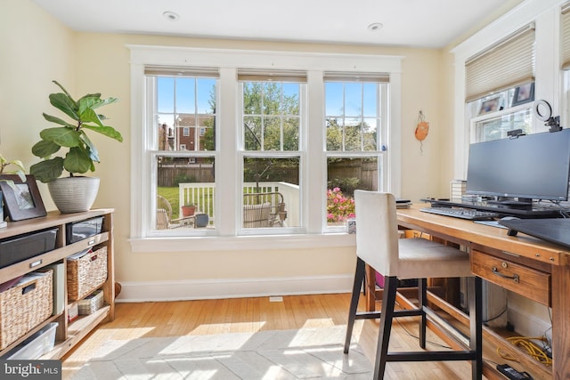 office space with baseboards and light wood-style floors