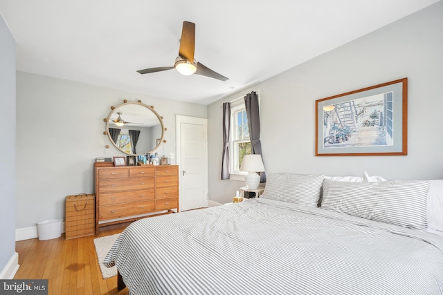 bedroom featuring a ceiling fan, baseboards, and hardwood / wood-style flooring